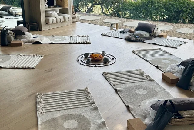 Mats arranged in a circle around a small altar of flowers and stones