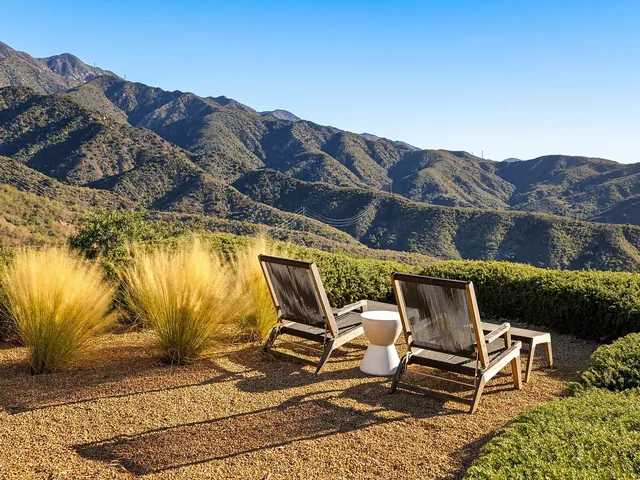 Two loungers facing the Santa Ynez mountains across ornamental grasses
